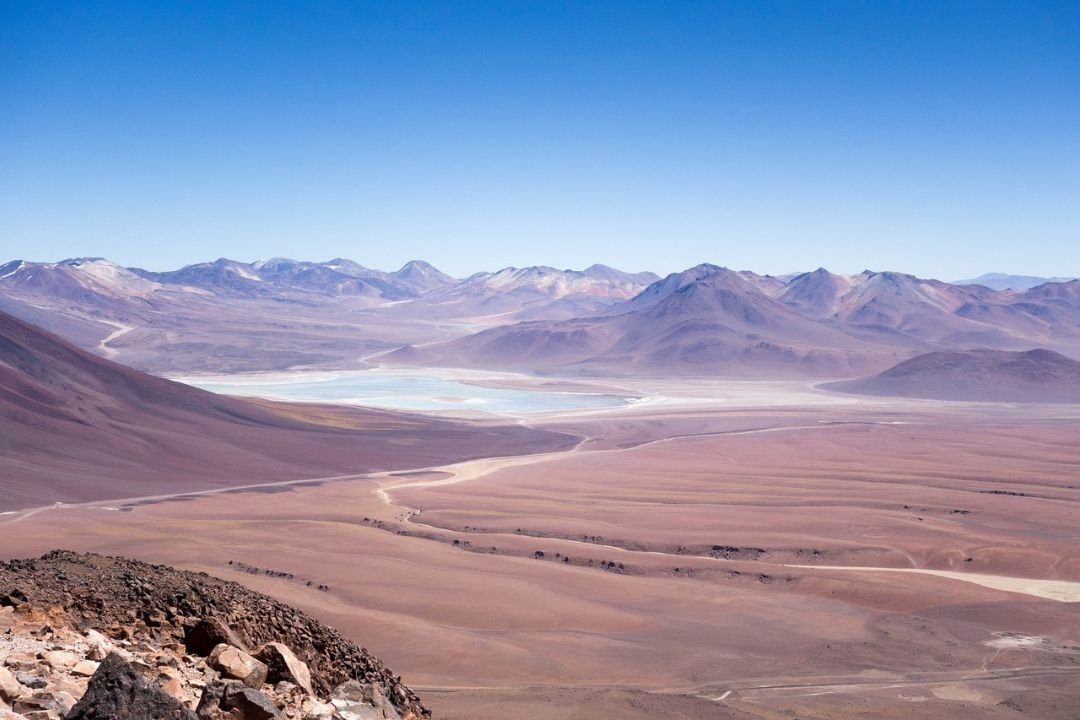 imagen maravillosa de una laguna verde y de fondo varias montañas que la rodean en la reserva Eduardo Avaroa. Potosí.