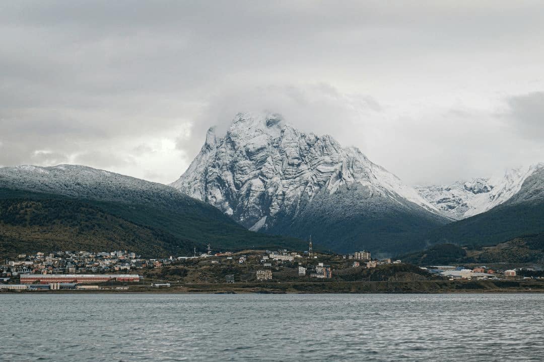 ciudad de Ushuaia de fondo una montaña cubierta de nieve.