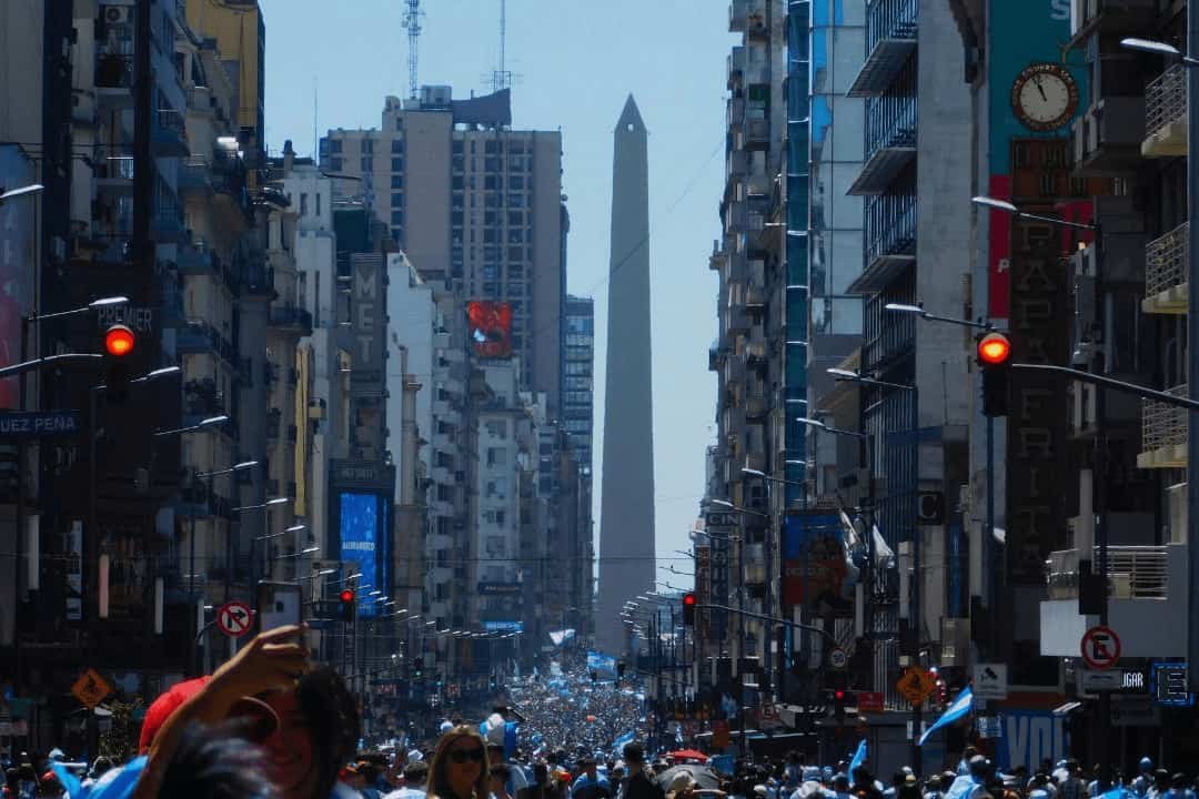 vista de la avenida 9 de julio con hinchas de argentina festejando la copa del mundo de futbol 2022 y de fondo en obelisco.